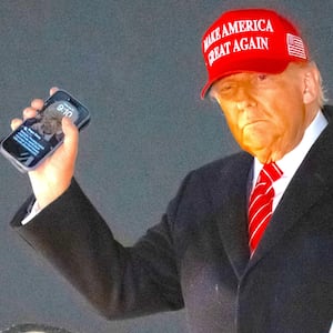 President Donald Trump disembarks from Air Force One while holding his cellphone at Joint Base Andrews in Maryland, May 30, 2025.