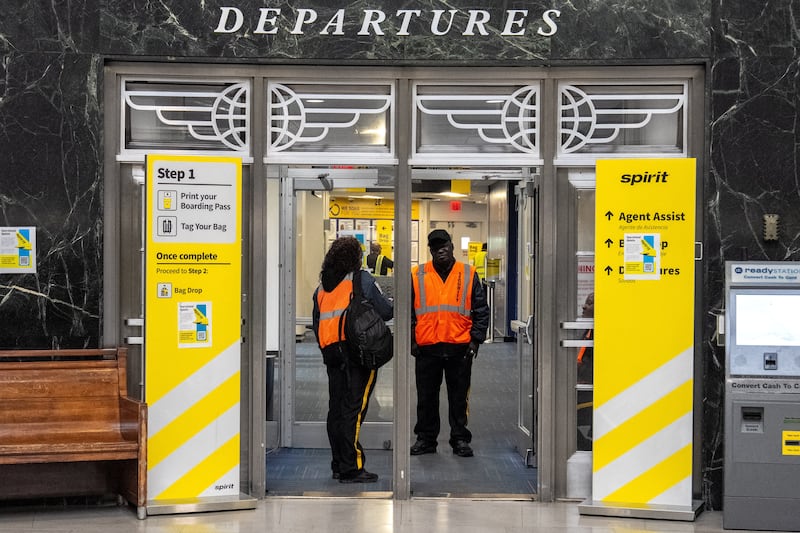 Security guards stand at the door of a boarding gate where signs inform passengers of the shutdown of Spirit Airlines at LaGuardia Airport in Queens, in New York City, U.S., May 2, 2026. REUTERS/David 'Dee' Delgado