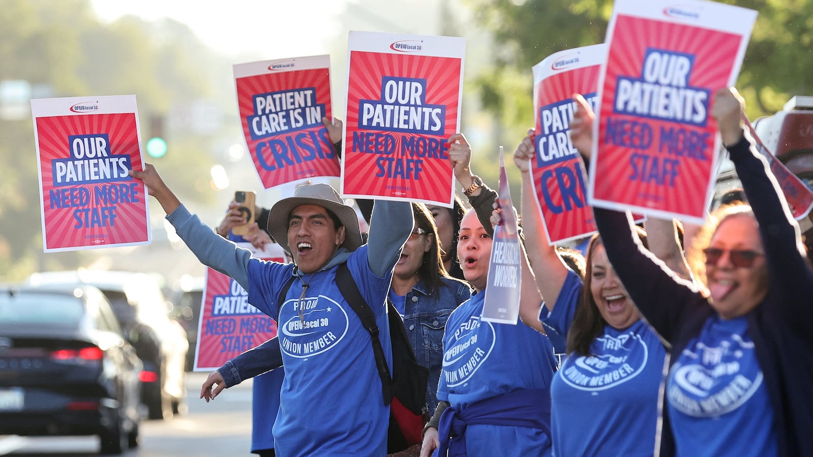 People hold placards, as a coalition of Kaiser Permanente Unions