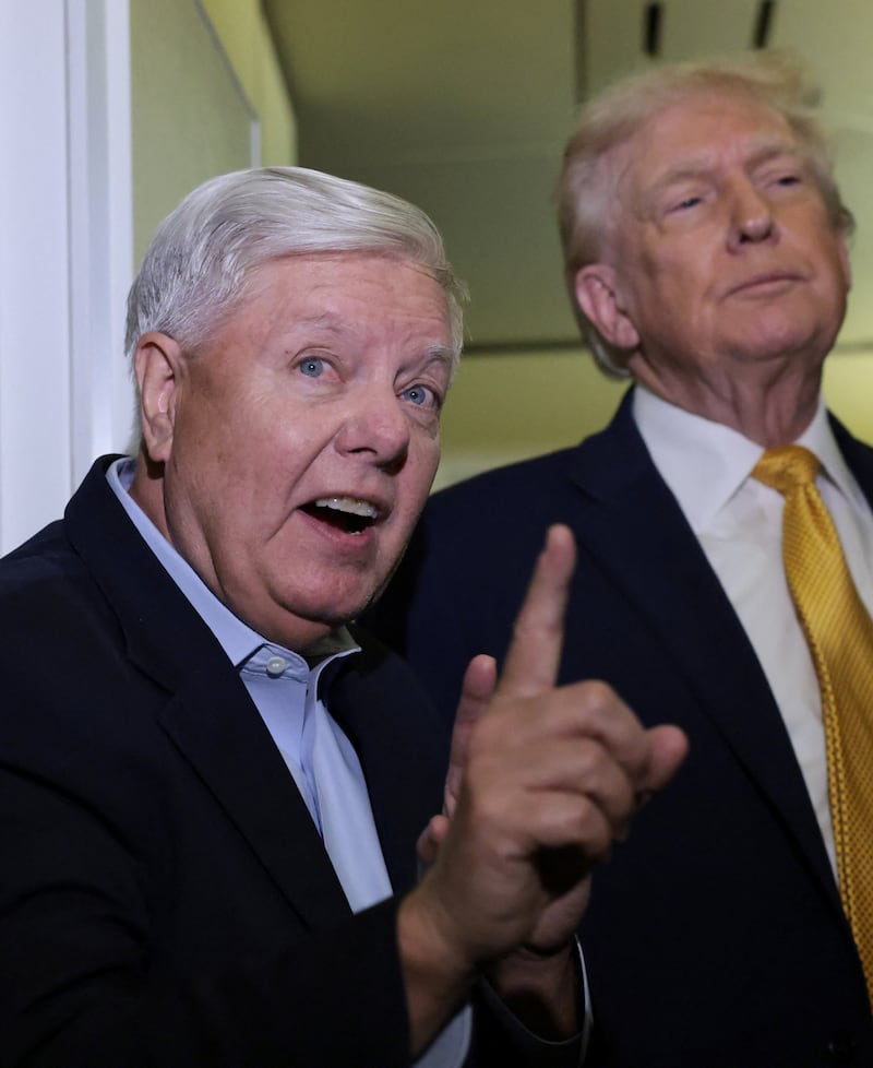 U.S. Senator Lindsey Graham (R-SC) joins President Donald Trump to speak to reporters aboard Air Force One en route from Florida to Joint Base Andrews, Maryland, U.S., January 4, 2026. REUTERS/Jonathan Ernst