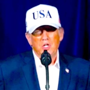 Donald Trump delivers a speech next to an image of smoke over Tehran, Iran.