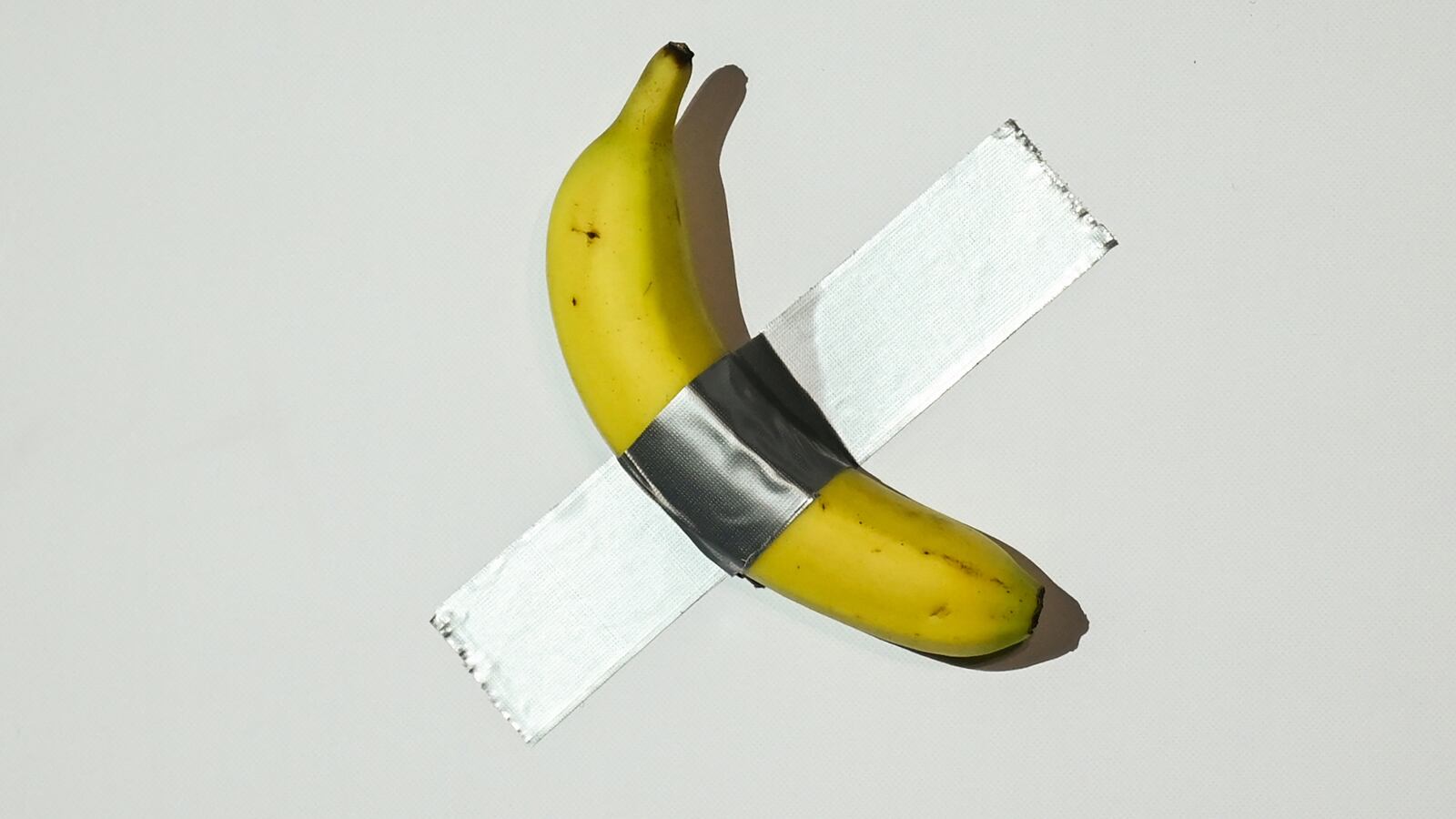 A banana artwork composed of a fresh banana stuck to a wall with duct tape is seen before being eaten by Chinese-born crypto founder Justin Sun in Hong Kong on November 29, 2024, after buying the provocative work of conceptual art by Italian artist Maurizio Cattelan at a New York auction for $6.2 million. The debut of the edible creation entitled "Comedian" at the Art Basel show in Miami Beach in 2019 sparked controversy and raised questions about whether it should be considered art -- Cattelan's stated aim. (Photo by Peter PARKS / AFP) (Photo by PETER PARKS/AFP via Getty Images)