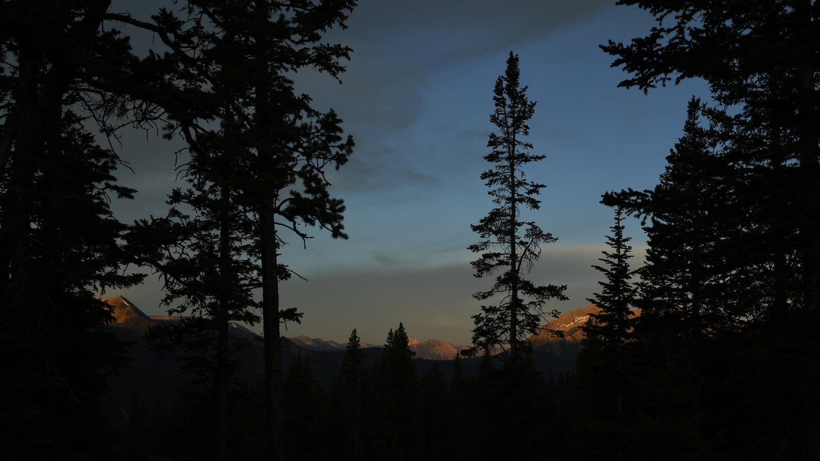 The sun rises on mountains in Colorado. Two sisters and a teenaged son, who were all found partially mummified at a remote Colorado campsite in July after telling family they were living “off the grid,” died of hypothermia and malnutrition.