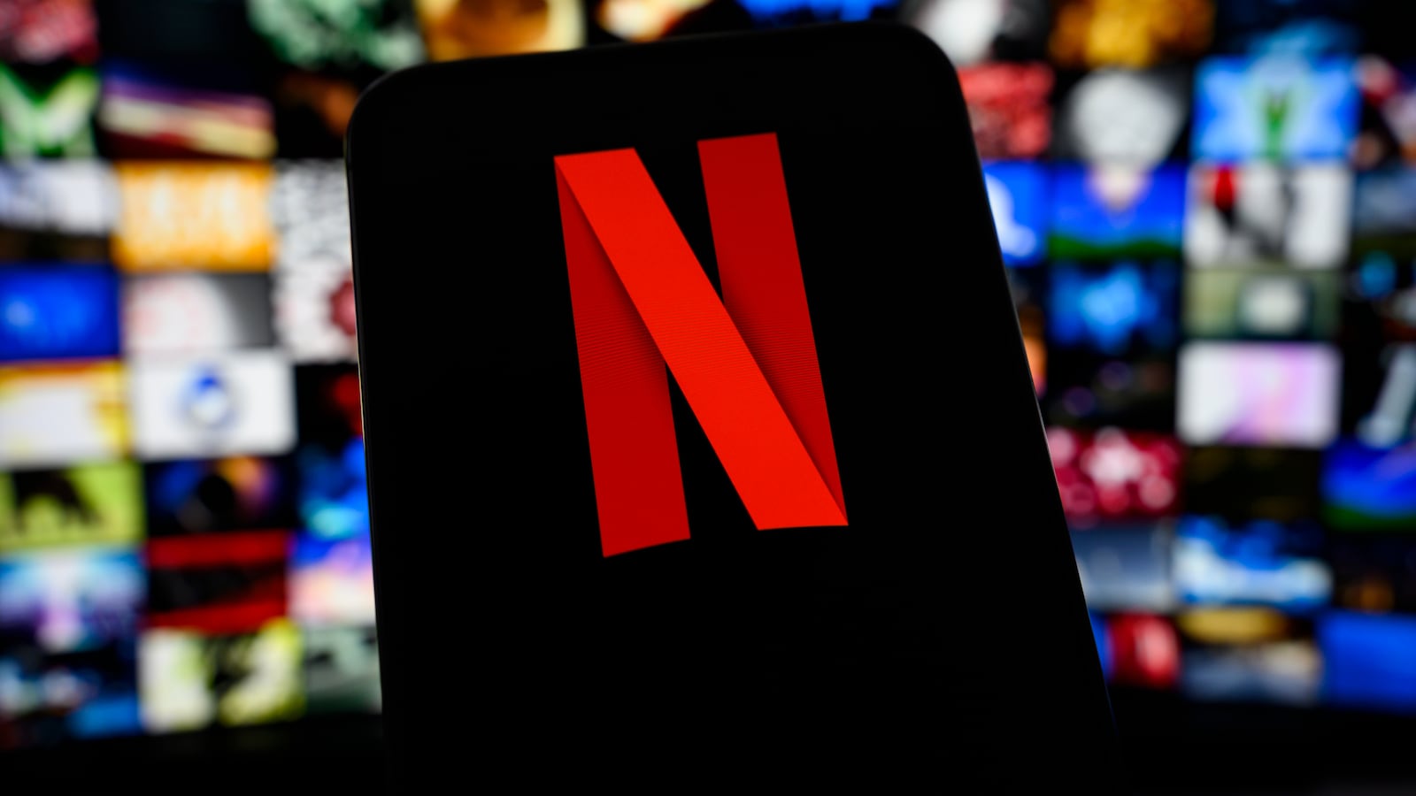 The Netflix logo appears on a smartphone screen with a blurred mosaic of streaming content in the background, as the streaming platform releases its Q1 2026 results, in Creteil, France, on April 17, 2026. (Photo by Samuel Boivin/NurPhoto via Getty Images)