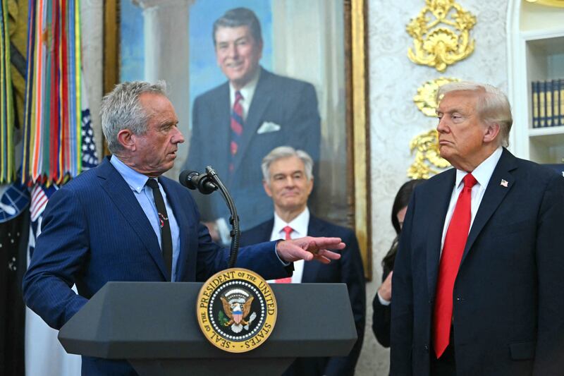 US President Donald Trump listens to US Secretary of Health and Human Services Robert F. Kennedy Jr. (L) during an announcement in the Oval Office of the White House in Washington, DC, on October 16, 2025.