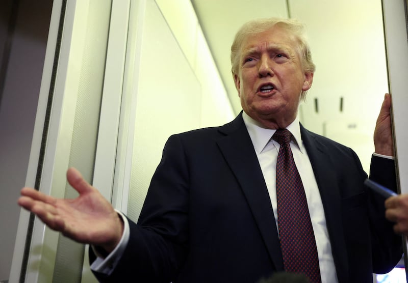 U.S. President Donald Trump speaks to reporters aboard Air Force One on a flight back to Washington March 15, 2026.