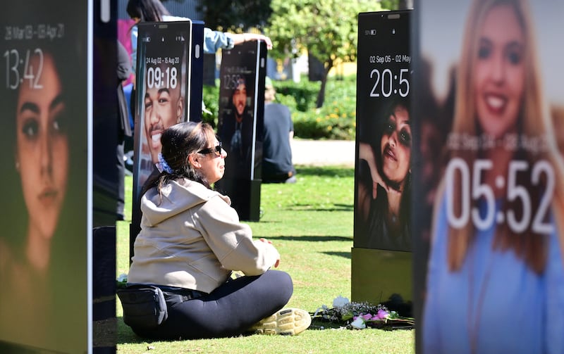Bereaved parents view images of their deceased children displayed at the 'Lost Screen Memorial', an art installation of large-scale smartphones featuring 50 children who lost their lives due to online harm, in Los Angeles, California on February 13, 2026. Meta and Google-owned YouTube were accused on February 9, 2026, of pushing highly addictive apps on children as a landmark social media trial began in earnest in a California court. The blockbuster trial in front of a Los Angeles jury could establish a legal precedent on whether the social media juggernauts deliberately designed their platforms to lead to addiction in children. (Photo by Frederic J. BROWN / AFP via Getty Images)
