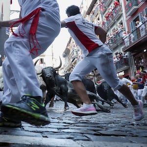 Revelers sprint from raging bulls in Spain.