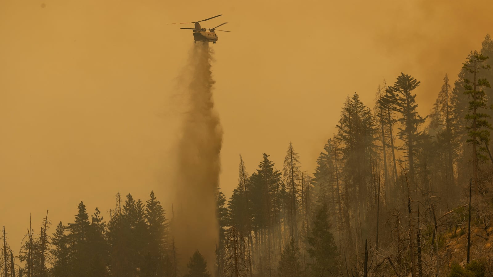 A Billings 4AJ helicopter makes a water drop at the Oak Fire near Mariposa, California, on July 26, 2022.