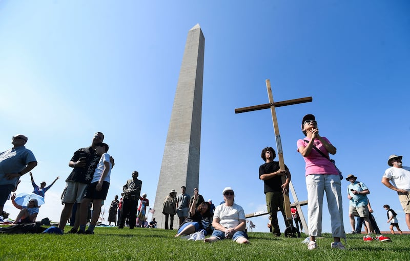 TOPSHOT - Christian worshipers attend the Roots of Revival event at the Washington Monument, held a day ahead of "Rededicate 250: A National Jubilee of Prayer, Praise and Thanksgiving" in Washington, DC, on May 16, 2026. (Photo by Matthew Hatcher / AFP via Getty Images)