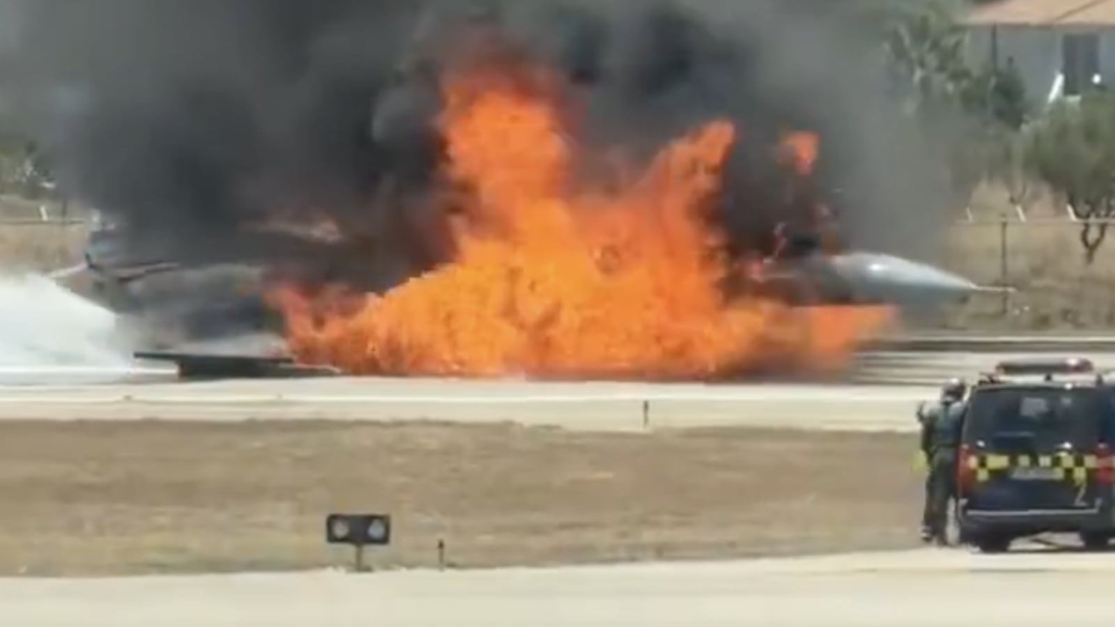 The Hellenic Air Force F-16 ablaze on the runway at Zakynthos International Airport as emergency teams battle the flames.