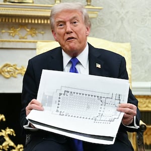 US President Donald Trump shows the floor plan of his planned ballroom.