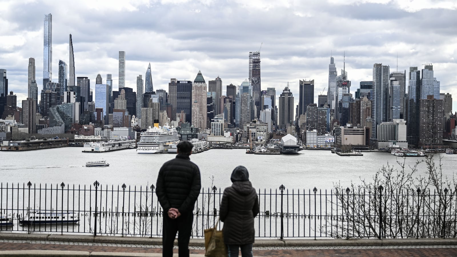 A view of the New York City skyline from across the Hudson River, with people standing at the water’s edge, shortly after an earthquake occurred on Friday.