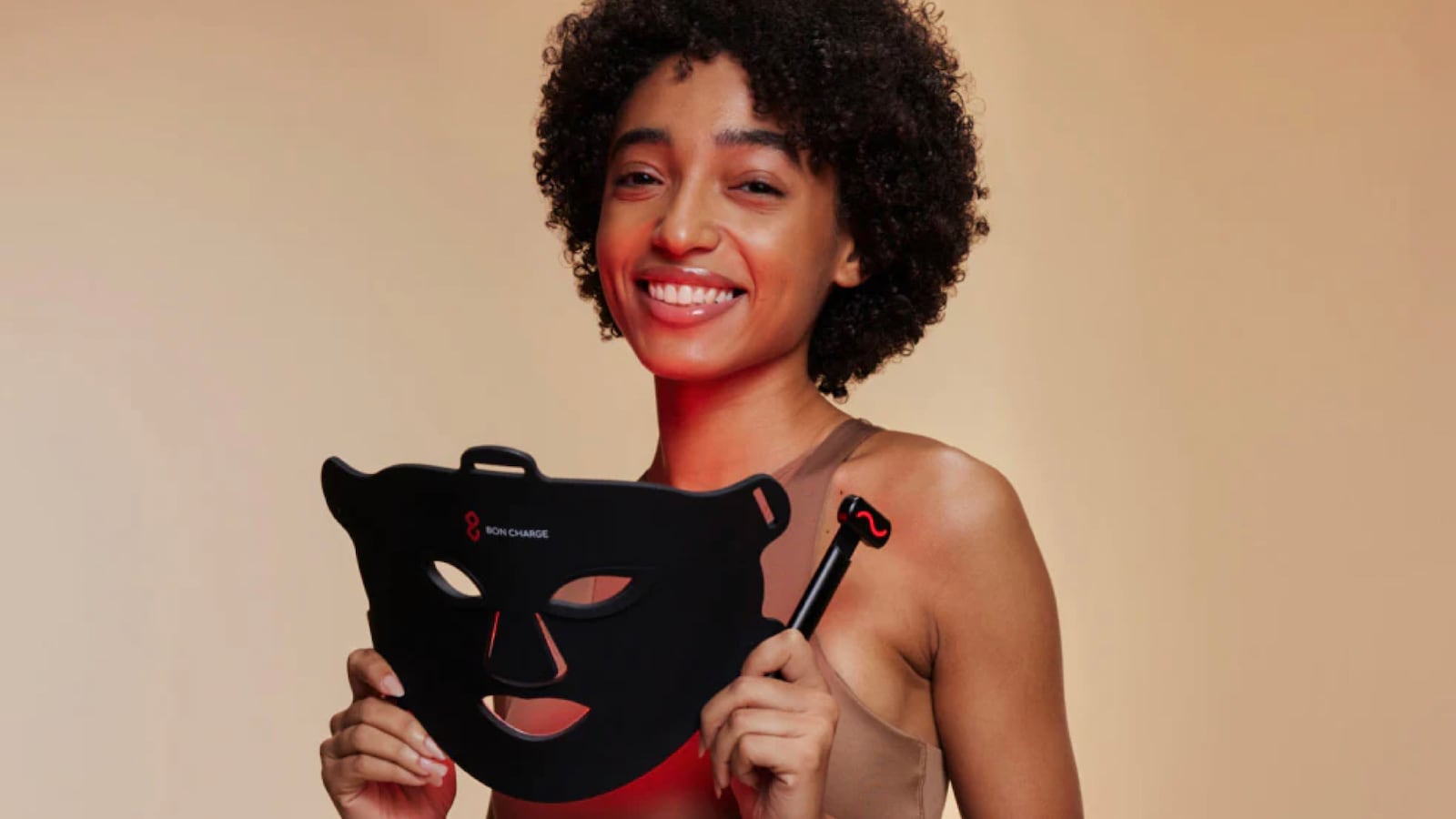 Woman holding a red light face mask from Bon Charge