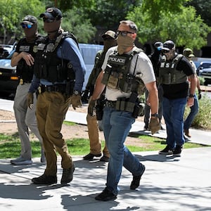 Masked law enforcement officers, including HSI and ICE agents, walk into an immigration court in Phoenix, Arizona, U.S., May 21, 2025.