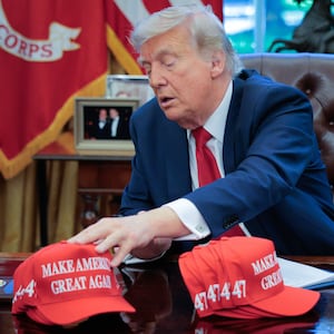 President Donald Trump adjusts "Make America Great Again" hats.