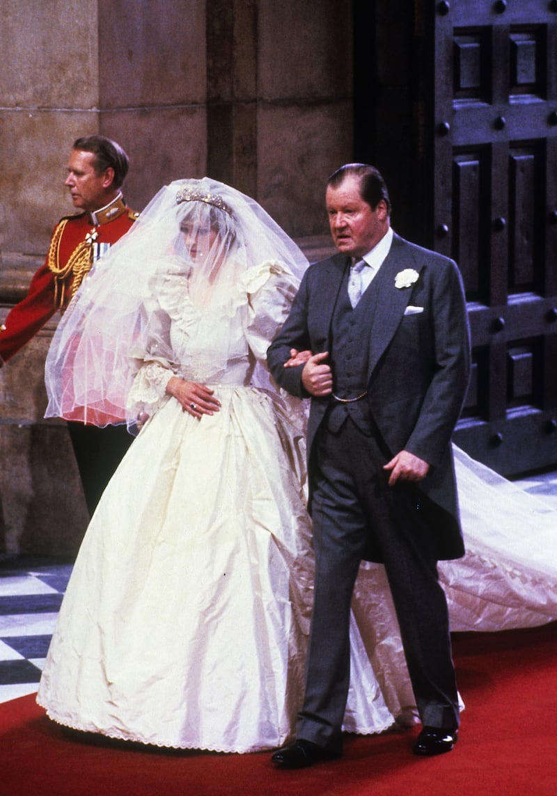 LONDON, ENGLAND - JULY 29: Lady Diana Spencer, wearing a wedding dress designed by David and Elizabeth Emanuel and the Spencer family Tiara, enters St. Paul's Cathedral on the hand of her father, Earl Spencer, ahead of her marriage to Prince Charles, Prince of Wales on July 29, 1981 in London, England. (Photo by Anwar Hussein/Getty Images)