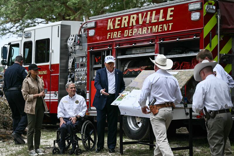 US President Donald Trump, Texas Governor Greg Abbott, and First Lady Melania Trump meet with local officials and first responders near the Guadalupe River following devastating flooding that ocurred in the area over the July 4 weekend, in Kerrville, Texas, on July 11, 2025. At least 120 people are dead and more than 170 still missing, following July 4 holiday weekend floods that ravaged the central Texas Hill Country -- including a river bank cluttered with children's summer camp cabins. (Photo by Brendan SMIALOWSKI / AFP) (Photo by BRENDAN SMIALOWSKI/AFP via Getty Images)