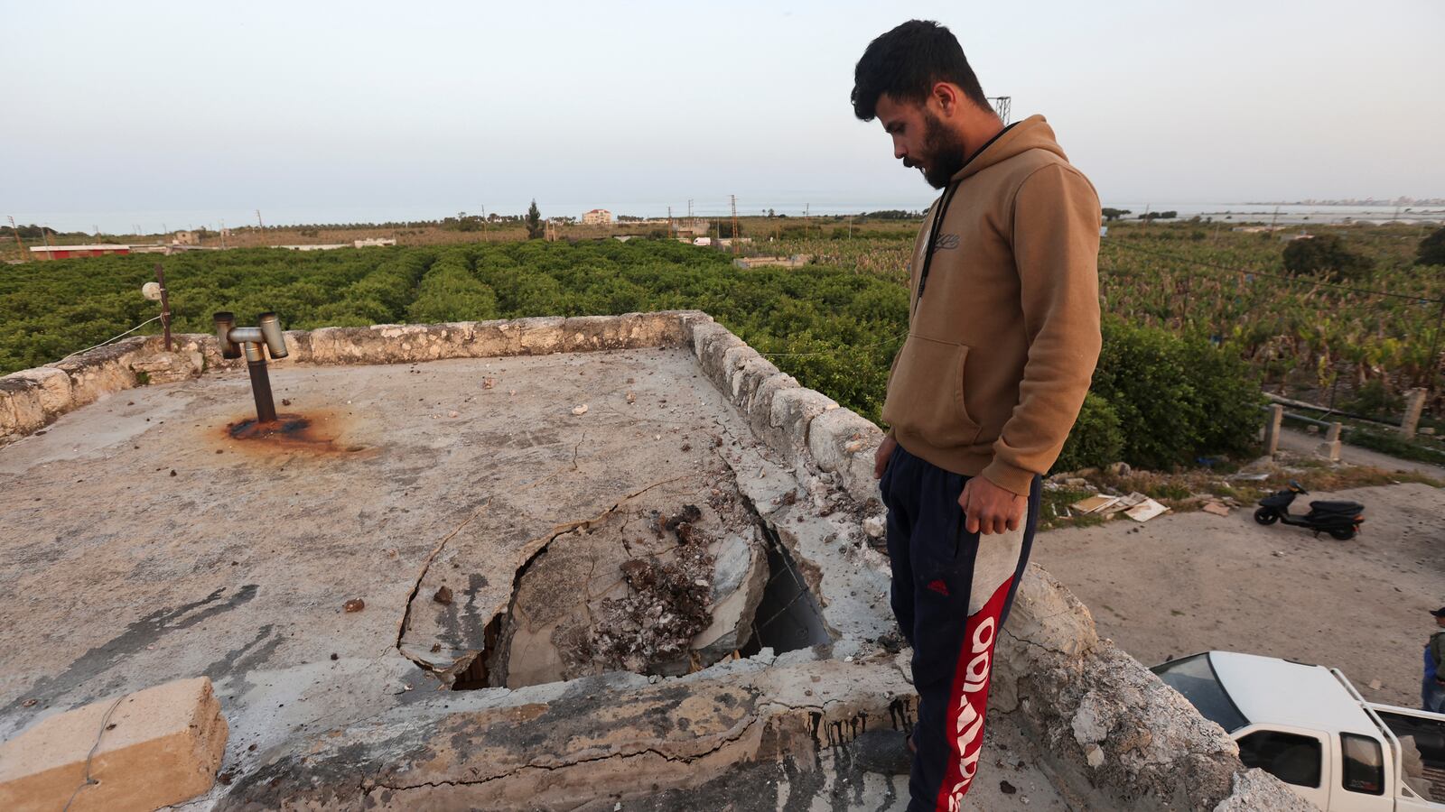A man stands near damage following Israeli air strikes in Al Qulaylah, southern Lebanon.