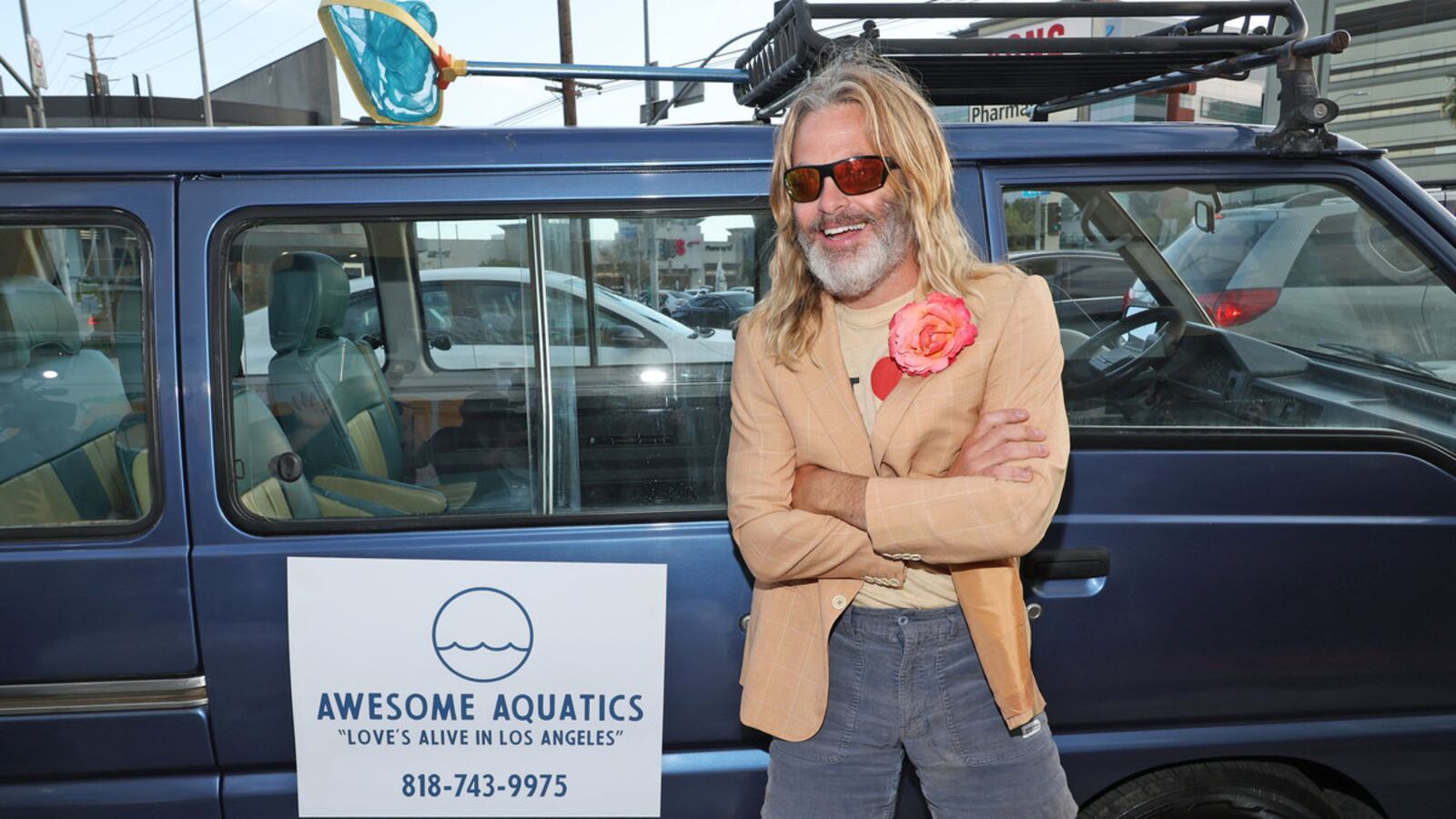 Chris Pine laughs as he stands in front of a pool repair van.