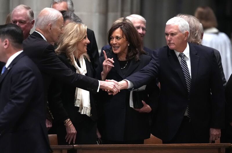 Former U.S. President Joe Biden shakes hands with former Vice President Mike Pence at Thursday’s service.