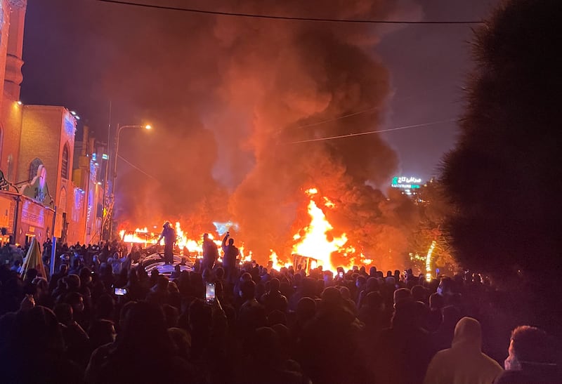 Iranian Protesters gather around burning cars near a masque while blocking a street during a protest in Tehran, Iran, on January 8, 2026.
