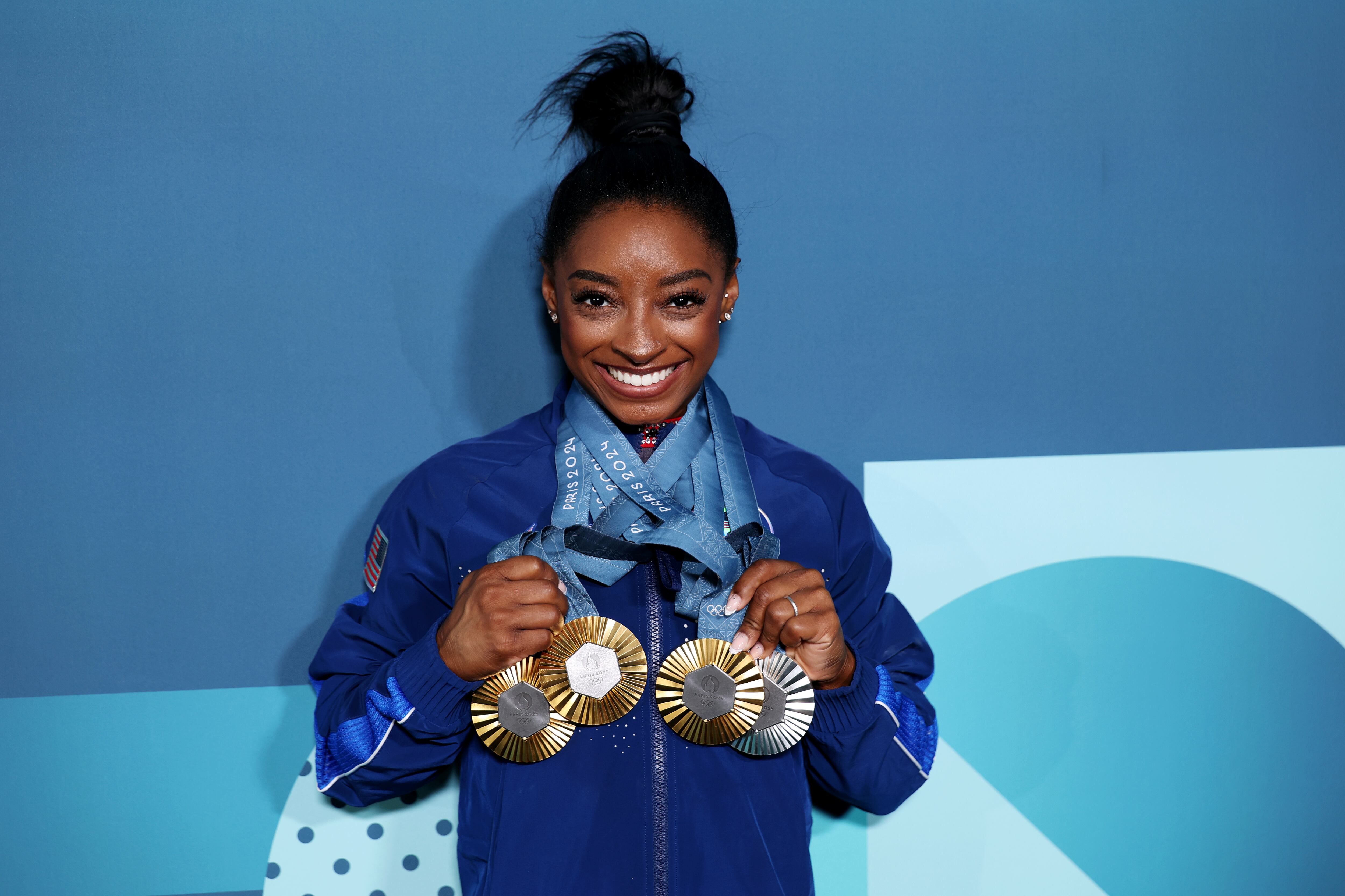 Simone Biles of Team United States poses with her Paris 2024 Olympic medals following the Artistic Gymnastics Women's Floor Exercise Final on day ten of the Olympic Games Paris 2024 at Bercy Arena on August 05, 2024 in Paris, France.