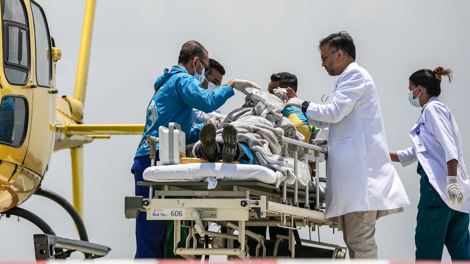 Medics and rescuers transfer mountaineer Dawa Sherpa from a helicopter upon his arrival at the HAMS Hospital in Kathmandu on June 4, 2026. A Nepali climbing guide who went missing on Mount Everest for six days and was believed dead has been found alive after crawling alone almost to Base Camp, officials told AFP on June 4. (Photo by PRABIN RANABHAT / AFP via Getty Images)