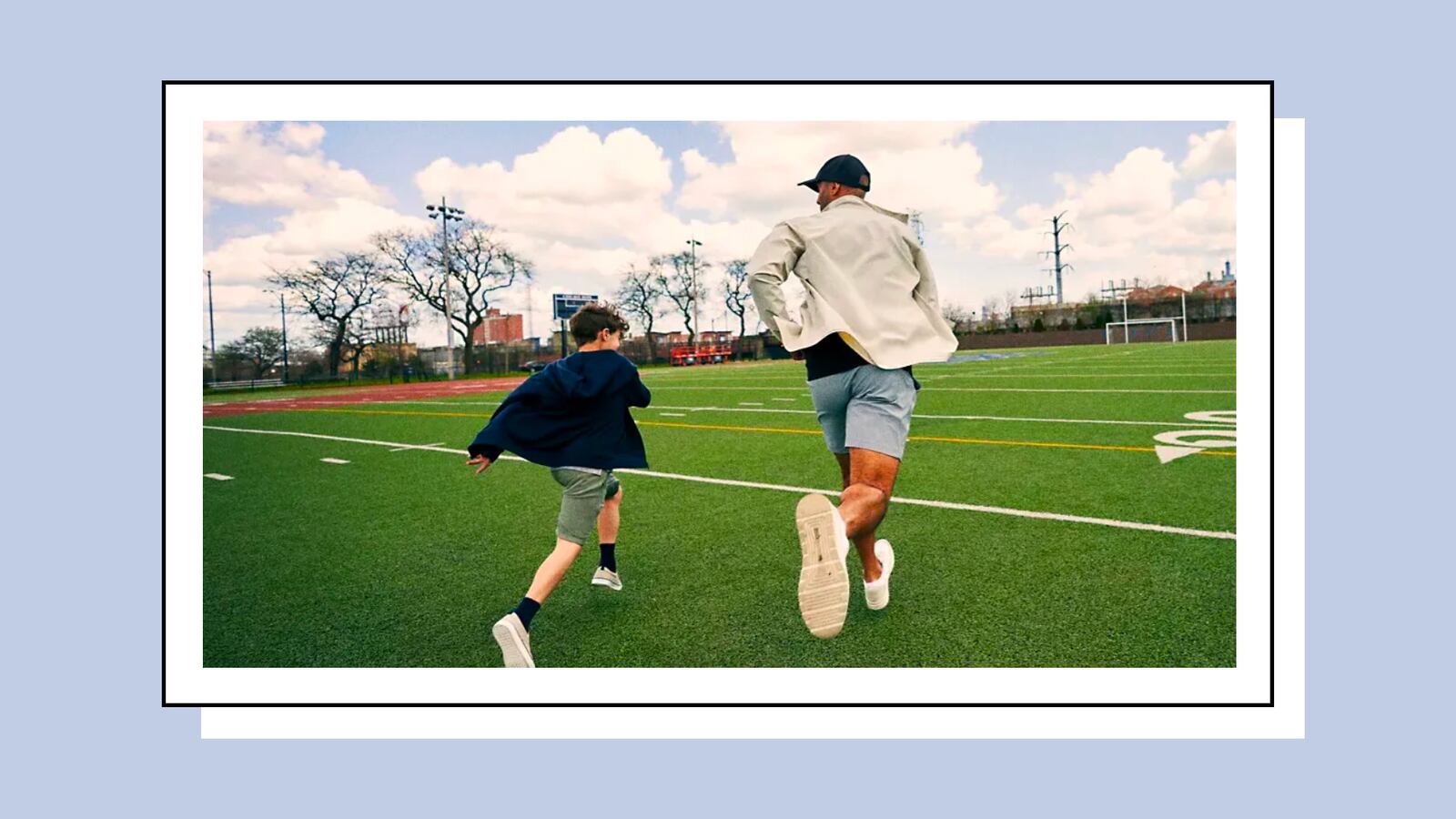 Father and son playing on a football field.