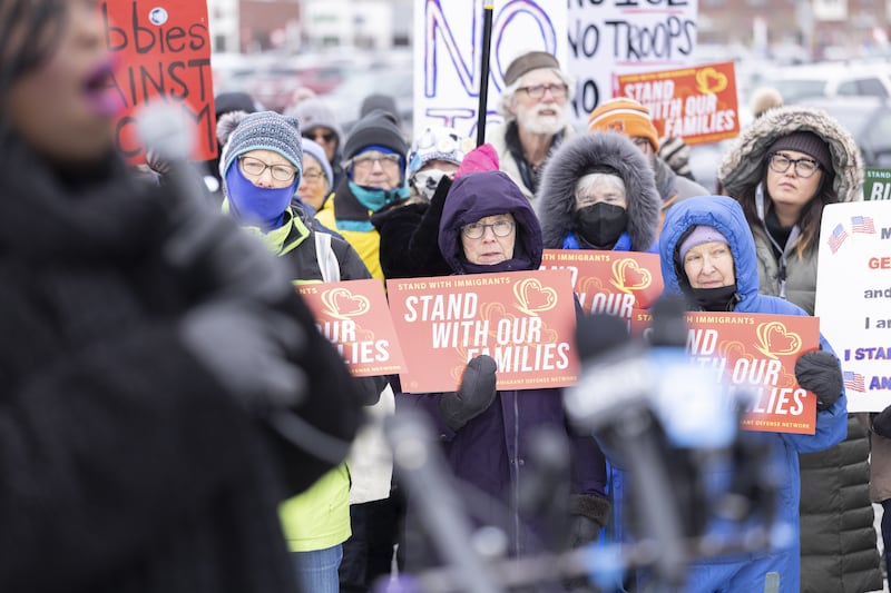 Community members hold banners as they show up to a press conference to demand accountability