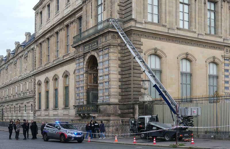French police officers stand next to a furniture elevator used by robbers to enter the Louvre Museum, on Quai Francois Mitterrand, in Paris on October 19, 2025. Robbers broke in to the Louvre and fled with jewellery on October 19, 2025 morning, a source close to the case said, adding that its value was still being evaluated. A police source said an unknown number of thieves arrived on a scooter armed with small chainsaws and used a goods lift to reach the room they were targeting. (Photo by Dimitar DILKOFF / AFP) (Photo by DIMITAR DILKOFF/AFP via Getty Images)