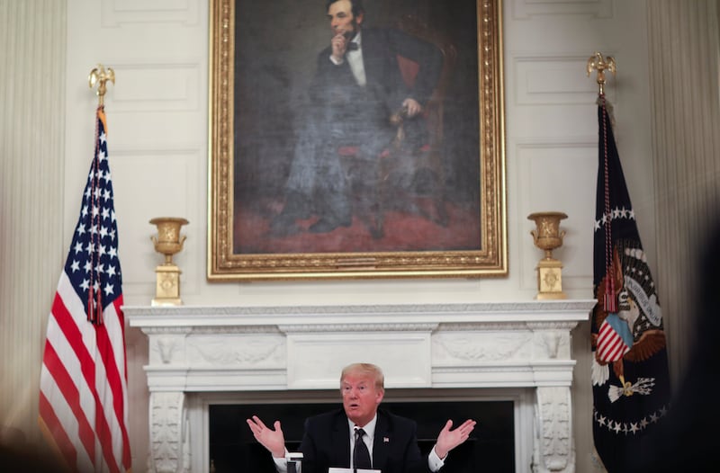 U.S. President Donald Trump talks about taking daily doses of hydroxychloroquine pills as he addresses a coronavirus disease (COVID-19) pandemic meeting with restaurant executives and industry leaders beneath a portrait of President Abraham Lincoln in the State Dining Room at the White House in Washington, U.S., May 18, 2020. REUTERS/Leah Millis