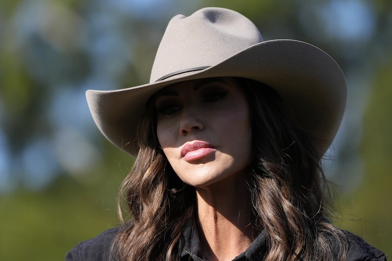 Kristi Noem, in a cowboy hat, speaks to the press upon arrival at the Campo De Mayo Military Base on July 28, 2025, in Buenos Aires, Argentina.