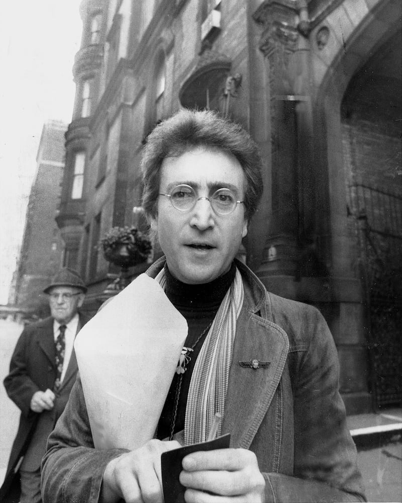 John Lennon outside his apartment building in New York City