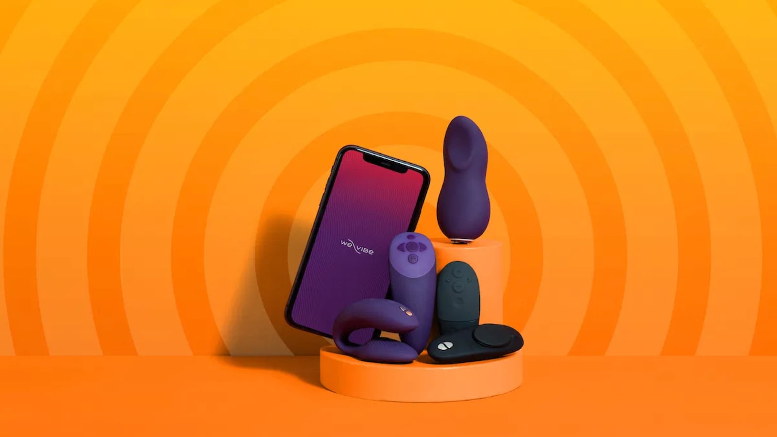 A collection of vibrators and other sex toys on an orange background. There is phone to show that some of the toys can be controlled remotely.