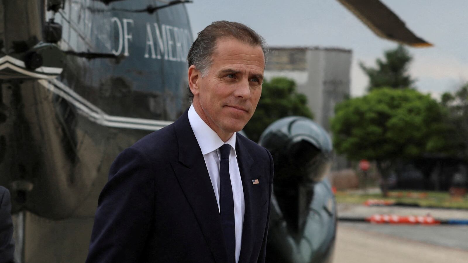 Hunter Biden, in a suit, strides by Marine One.