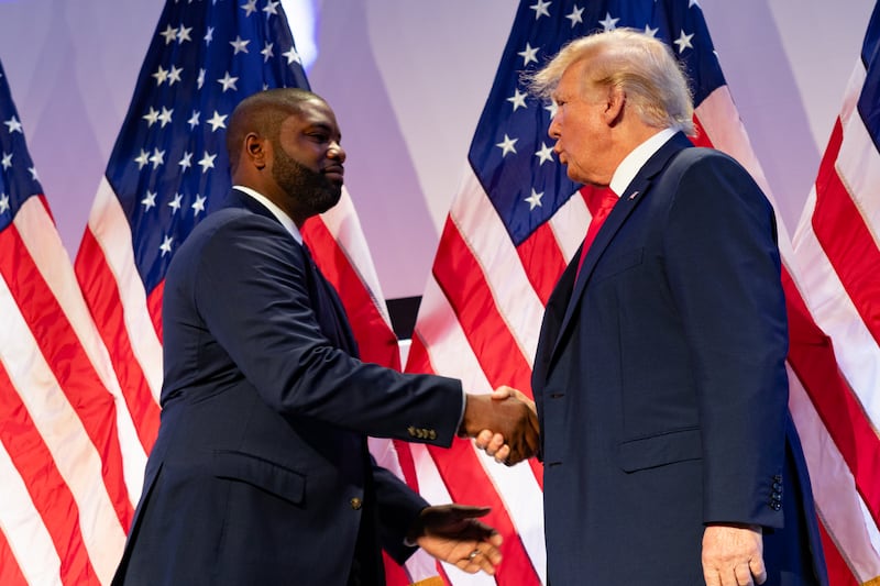 Byron Donalds shakes hands with Donald Trump at the Moms for Liberty Summit in Philadelphia, Pennsylvania, 2023.