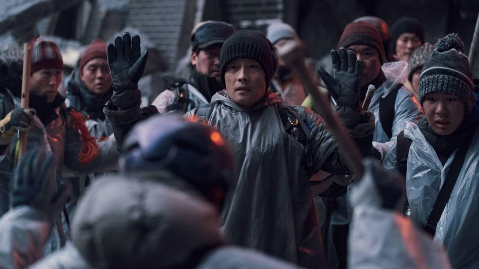 Lee Byung-hun holds his hands up in a still from Concrete Utopia