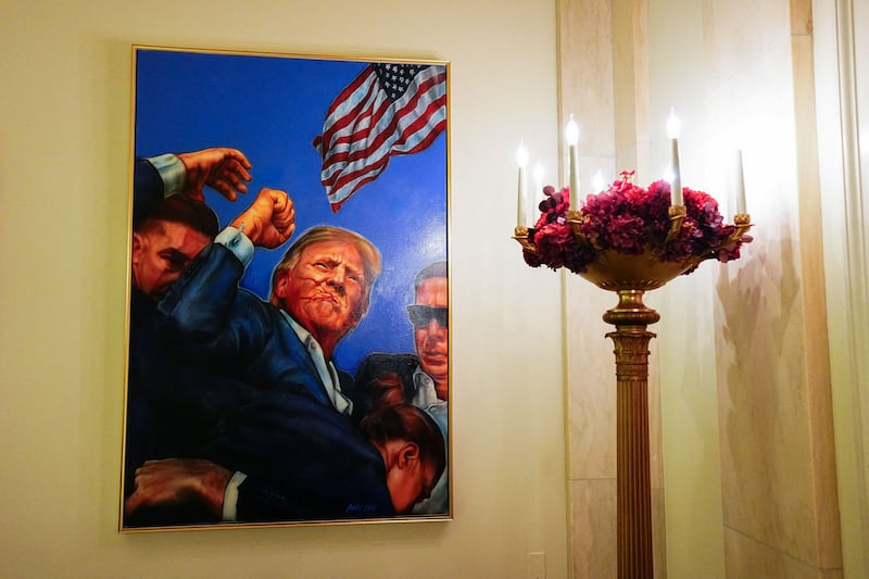 A painting of the attempted assassination of President Trump in the Grand Foyer of the White House during a media preview of the 2025 holiday decorations at the White House, December 1. The White House kicked off the holiday season by unveiling a display that included more than 50 Christmas trees, 25,000 feet of ribbon, and a painting of Trump holding up his fist moments after he was shot. REUTERS/Aaron Schwartz