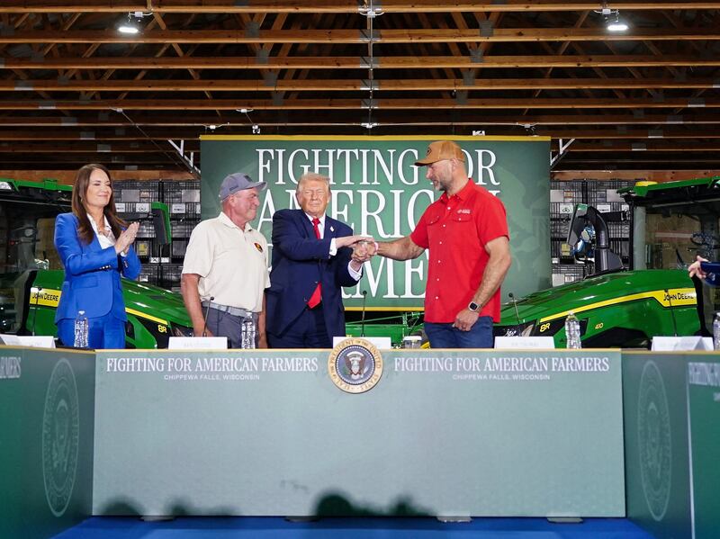 U.S. President Donald Trump shakes hands with Joe Thomas, while standing next to Ken Custer during an event at Custer Farms in Chippewa Falls, Wisconsin, U.S., June, 5, 2026.