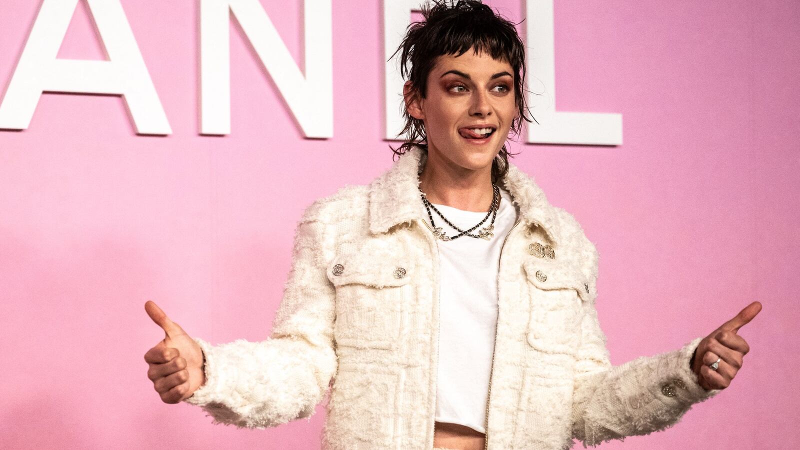 Kristen Stewart holds her thumbs up at a Chanel show