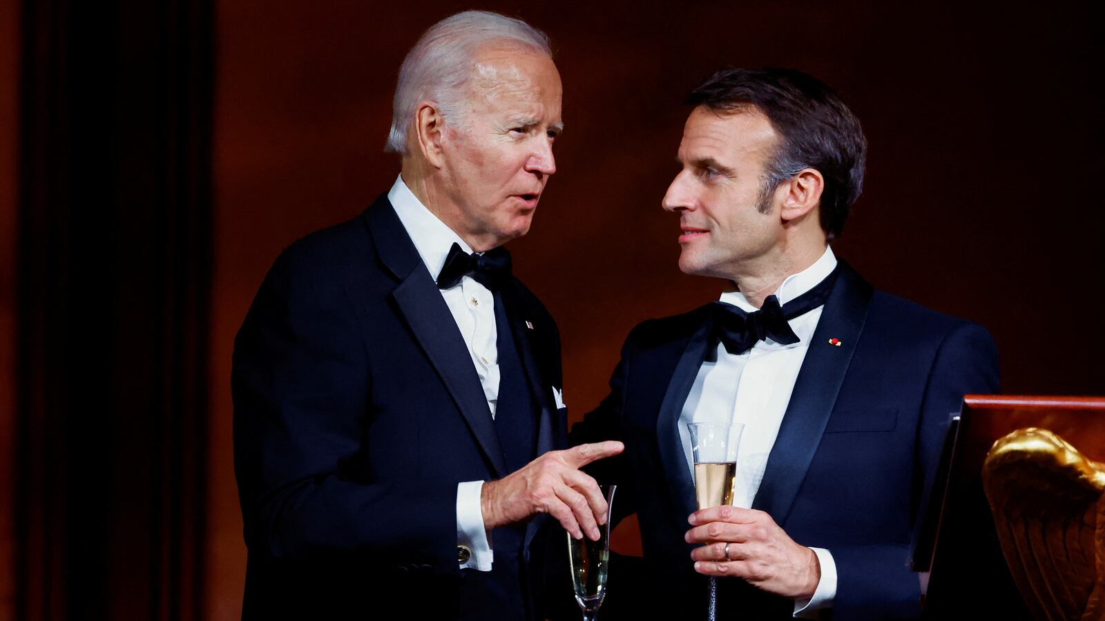 Joe Biden speaks to France's President Emmanuel Macron while they make a toast, as the Bidens host the Macrons for a State Dinner at the White House, in Washington, U.S., December 1, 2022.