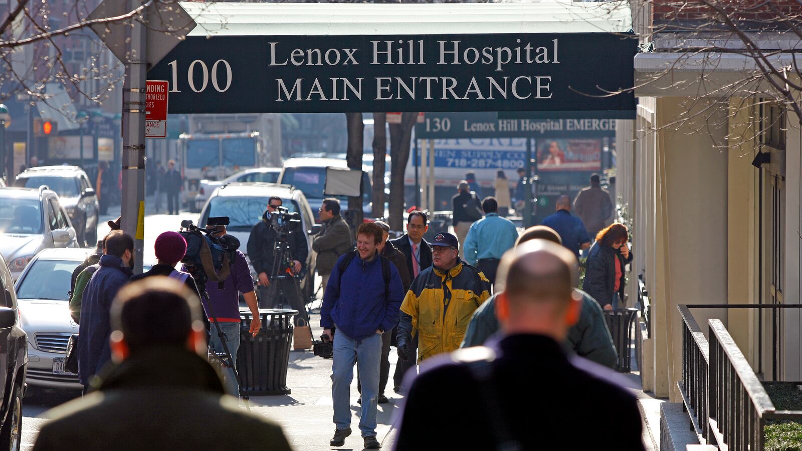 People walk on the sidewalk near the main entrance of Lenox Hill Hospital in New York City.