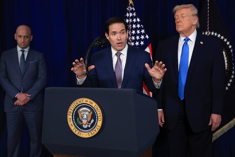 PALM BEACH, FLORIDA - JANUARY 03: Secretary of State Marco Rubio speaks during a press conference as Homeland Security Advisor Stephen Miller and U.S. President Donald Trump listen at Mar-a-Lago club on January 03, 2026, in Palm Beach, Florida. During the event, President Trump confirmed that the United States military carried out a large-scale strike in Caracas overnight, resulting in the capture of Venezuelan leader Nicolás Maduro and his wife, Cilia Flores.  (Photo by Joe Raedle/Getty Images)