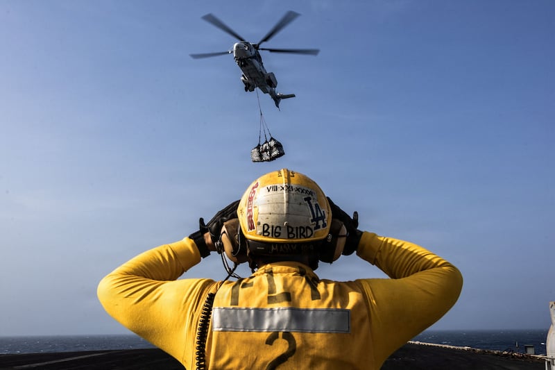 A helicopter delivers supplies to the USS Abraham Lincoln.