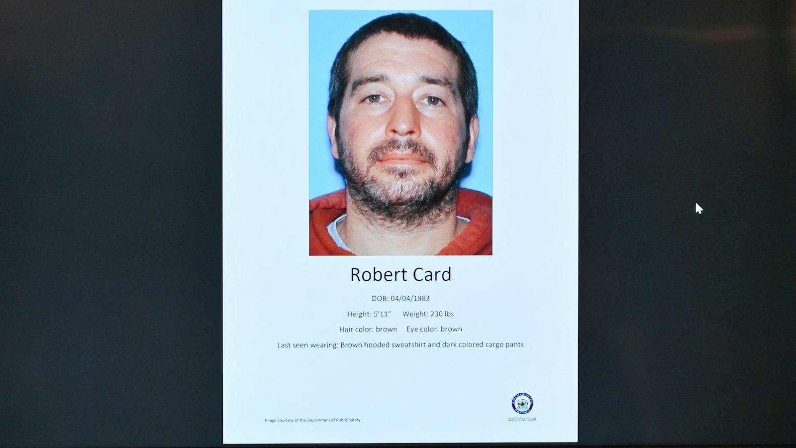 Maine Department of Public Safety Commissioner Mike Sauschuck speaks to the press during a press conference at Lewiston City Hall in Lewiston, Maine, under a picture of suspect Robert Card on October 27, 2023.