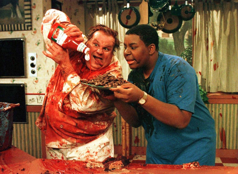 Actor Chris Farley (L) guest stars as "Chef Farley" in a recurring sketch "Cooking with Randy & ?" as he is covered with tomato catsup on the Nickelodeon cable channel program "All That," with cast member Kenan Thompson.
