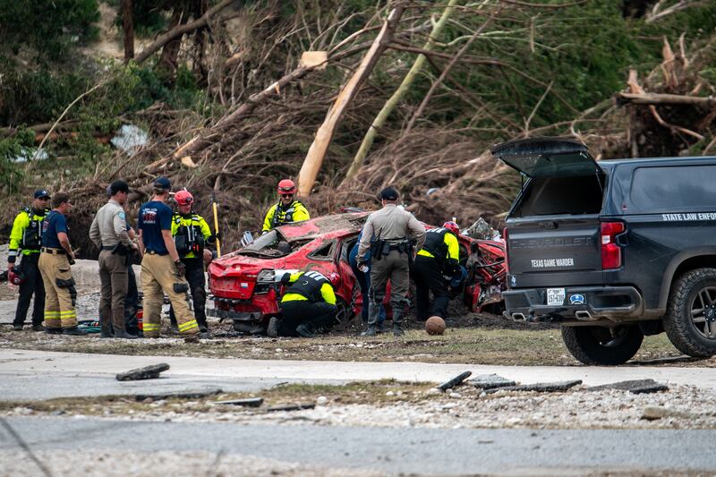 First responders attend to a vehicle pulled from the water in the aftermath of deadly flooding in Kerrville, Texas, U.S., July 6, 2025.   REUTERS/Sergio Flores