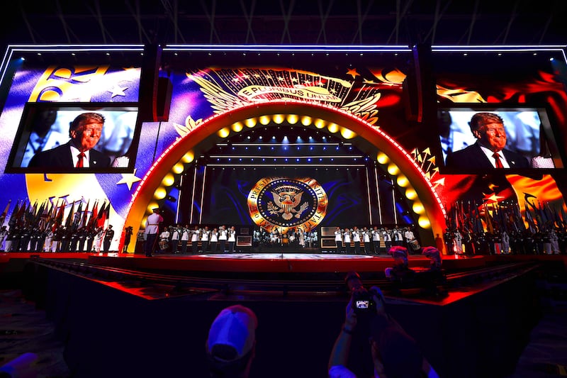 President Donald Trump is seen on the jombo screens as he walks on stage with U.S. First Lady Melania Trump