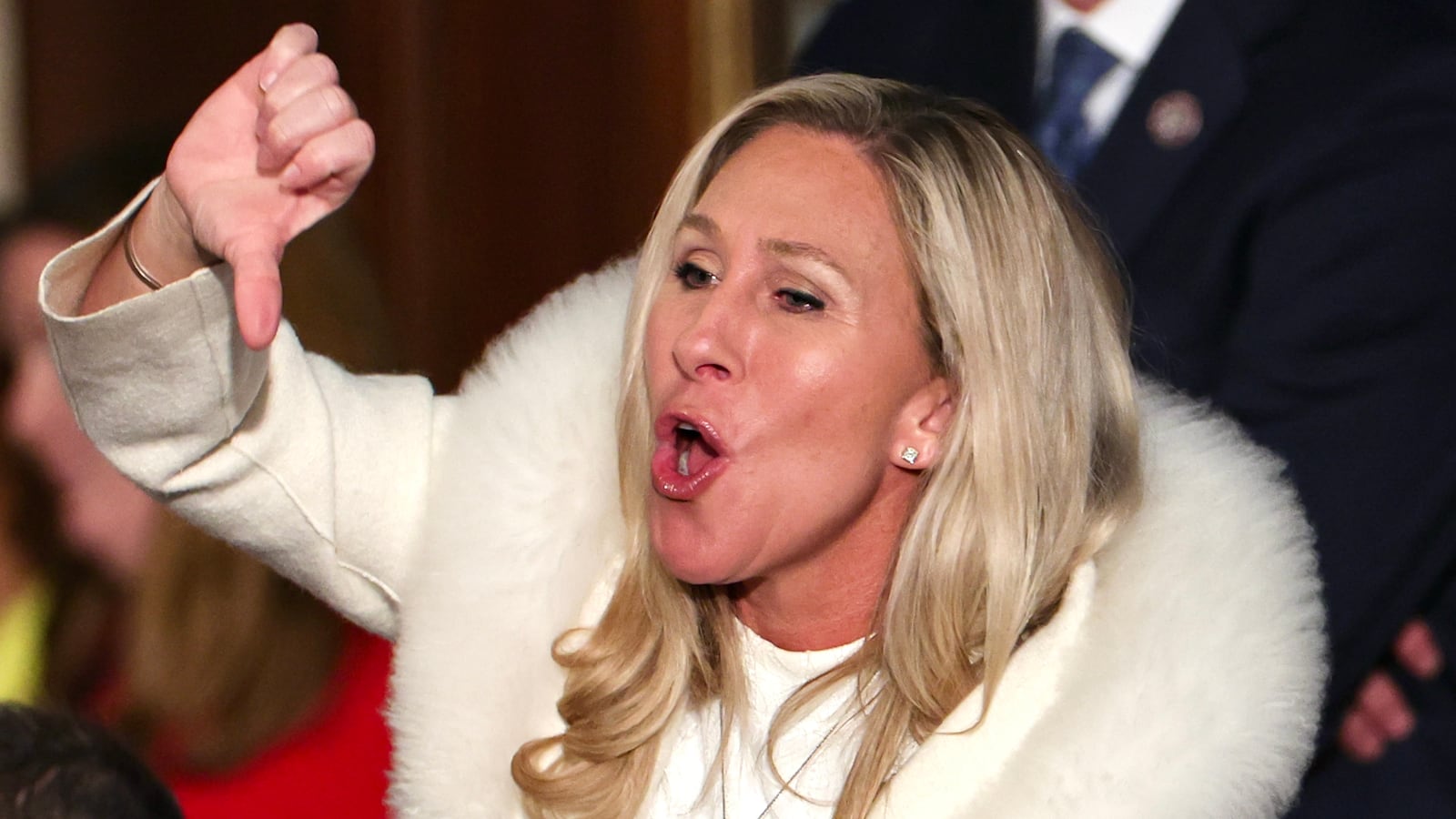 Marjorie Taylor Greene booing and giving a thumbs down gesture at Biden's State of the Union.